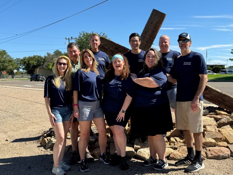 A group of smiling adults wearing Crossmark Global Investments t-shirts